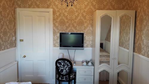 爱丁堡首都旅馆的客厅配有电视和椅子