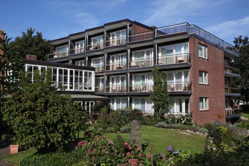 库克斯港伍赫伯格酒店的公寓大楼前方设有花园