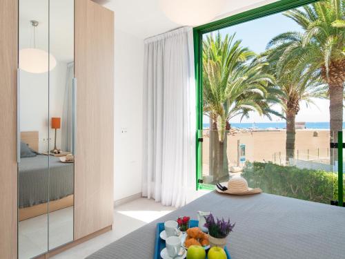 圣阿古斯丁Apartment Las Burras的卧室配有桌子,享有海滩美景