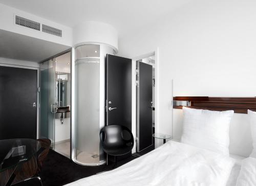 奥胡斯Wakeup - Aarhus的配有一张床和一把椅子的酒店客房