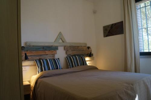 奥罗塞伊Sa Tanca de Mannoi的一间卧室配有一张带木制床头板的床