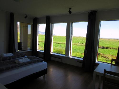Raudaberg兰达贝格二号乡村民宿的一间卧室设有一张床,窗户享有田野美景