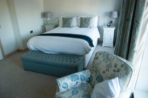 杜伦Castle View Guesthouse的一间卧室配有一张床、一把椅子和一把椅子