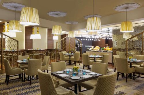 麦加马卡阿马尔凯悦酒店 的用餐室配有桌椅和吊灯。