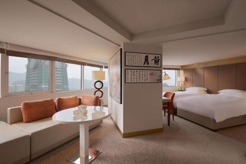 台北台北君悦酒店的酒店客房配有床、沙发和桌子。