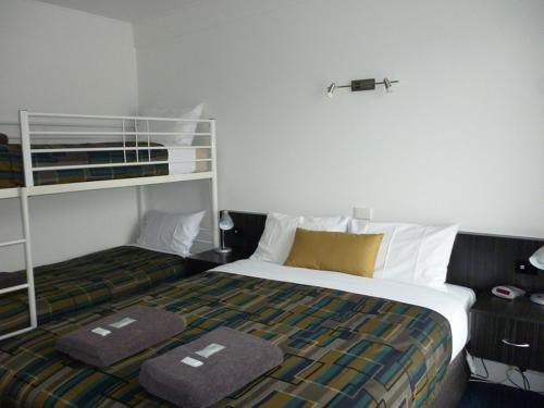 科拉克奥特威门汽车旅馆的一间卧室配有一张床和一张双层床。
