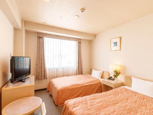 仙台仙台珍珠城市饭店的酒店客房设有两张床和电视。