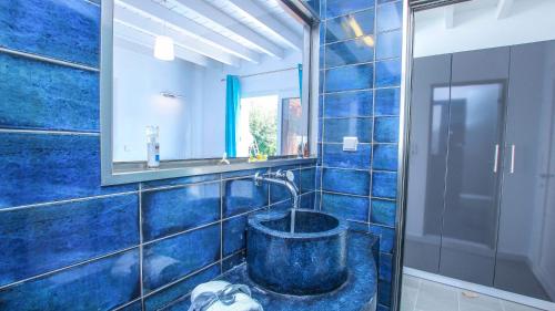 依克希亚Villa Elpiniki的蓝色瓷砖浴室设有浴缸和镜子