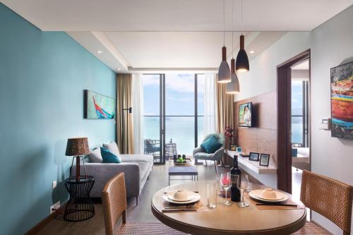 芽庄芽庄西塔迪纳海滨酒店的客厅配有桌子和沙发
