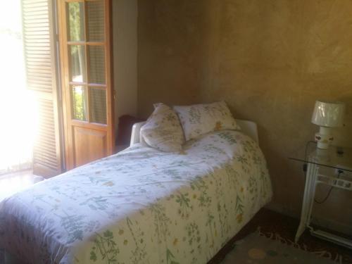 赫雷斯-德拉弗龙特拉Villa Marina的卧室配有一张带白色棉被的床和窗户。