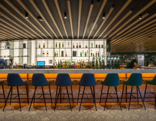 阿什本Pillo Hotel & Leisure Club的餐厅内的酒吧,带蓝色椅子