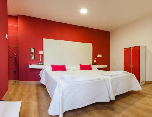 塞维利亚塞维利亚瑞充尔阿拉米达旅馆的红色卧室设有白色的床铺和红色的墙壁