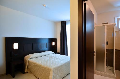 格罗塞托艾克雷斯皮酒店的一间卧室设有一张床和一个玻璃门