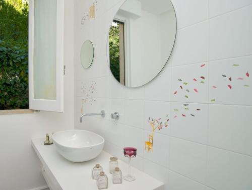 马拉泰亚罗曼蒂克企鹅塔埃利特餐厅酒店的浴室设有白色水槽和镜子