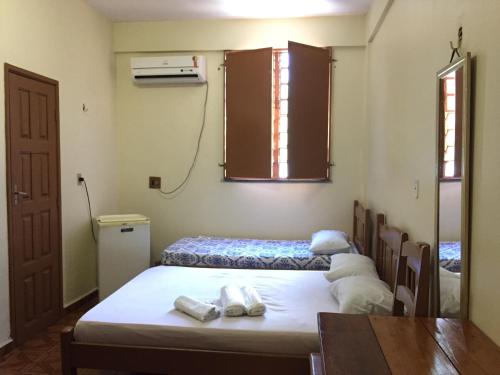 博阿维斯塔Hotel Ideal的客房设有两张床和一张带毛巾的桌子。