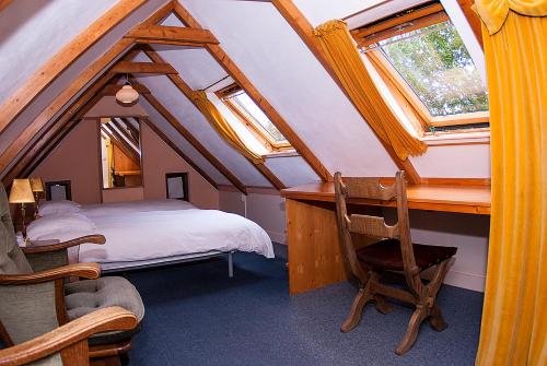 伊尔德帕特斯伍德B&B De Oude Molensteen的卧室配有一张床、一张书桌和窗户。
