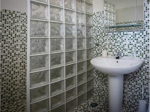 珀彻斯Vivenda Jardim Mar Algarve Porches的一间带水槽和玻璃墙的浴室