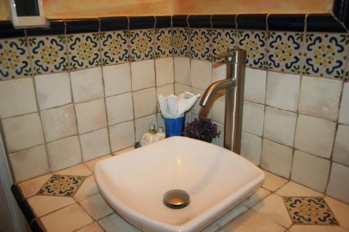 危地马拉老城酒店的浴室内设有一个白色水槽和水龙头