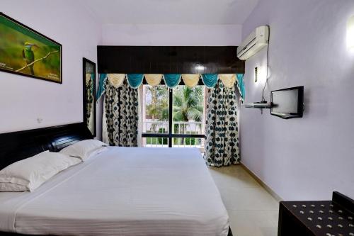 王舍城Indo Hokke Hotel的一间卧室设有一张大床和一个窗户。