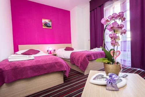卡维勒Hotel Villa Sandi - free parking的酒店客房设有两张床和紫色的墙壁。