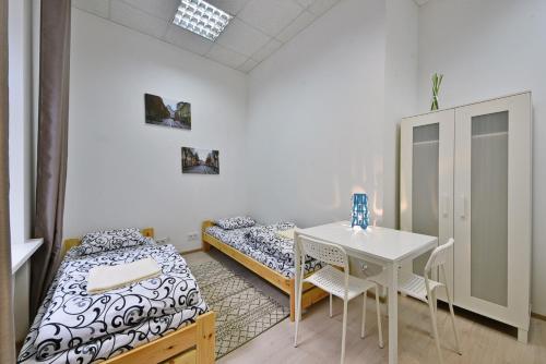 考纳斯Laisves Avenue Hostel "Easy Kaunas"的一间设有两张床和一张桌子及椅子的房间