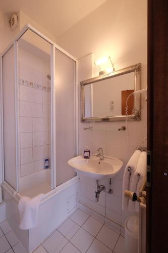 伦茨堡Hotel Grüner Kranz的白色的浴室设有水槽和淋浴。