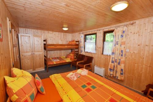 伏尔塔瓦河畔利普诺Lesní pension的一间卧室,卧室内配有一张床和一把椅子