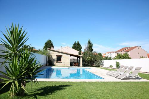 格罗韦Casa rural con piscina Viña de Millan的一个带2把躺椅的庭院内的游泳池