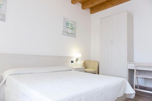 帕多瓦Residence Eremitani的白色卧室配有床和书桌
