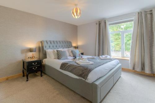 滨海凯斯特Beach Breeze Cottage - 3 Bed的一间卧室设有一张大床和一个窗户。