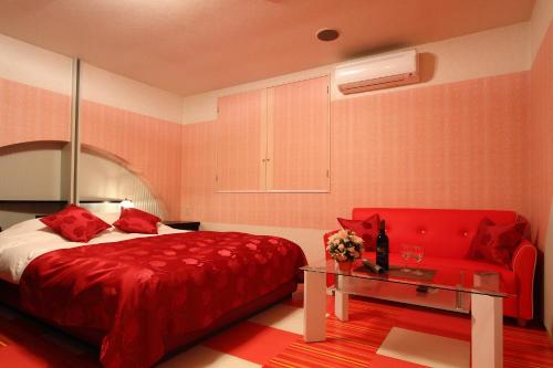 铫子市Restay Choshi Ragna (Adult Only)的一间卧室配有红色的床和红色的沙发