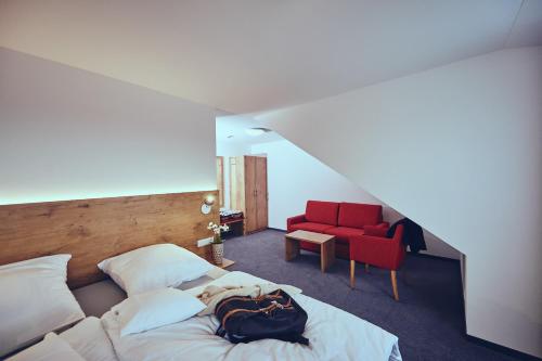 多瑙艾辛根Die Burg的一间卧室配有一张床和一张红色椅子