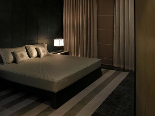 迪拜Armani Hotel Dubai, Burj Khalifa的一间卧室配有床、灯和窗帘