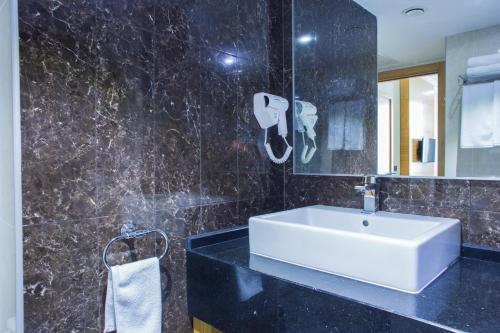 奇姆肯特Aidana Plaza Hotel的浴室设有白色水槽和镜子