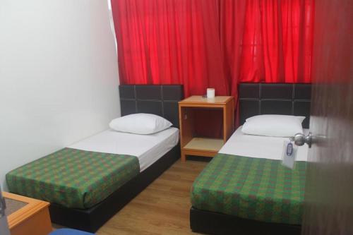 乔治市乔治敦赫里塔吉汽车旅馆的小房间设有两张床和红色窗帘