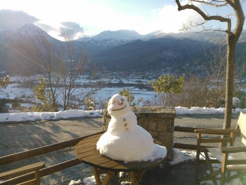 果拉Olvios Hotel的雪上雪人坐在桌子上