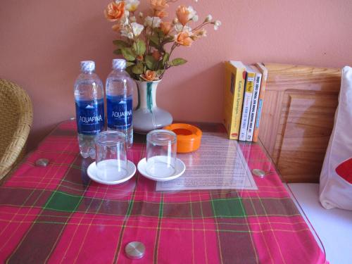 萨帕萨帕背包客青年旅舍的一张桌子,上面放着两瓶玻璃杯和花瓶