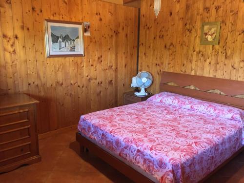 莫诺波利La Baita sul Mare的一间卧室设有一张床和木墙