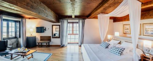 巴约讷巴约纳旅馆的一间带一张床的客厅和一间带沙发的客厅