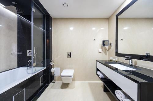 罗兹安姆巴什达尊享酒店的一间带水槽、卫生间和镜子的浴室