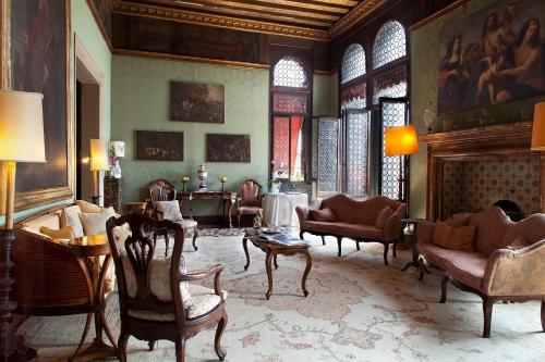 威尼斯大运河皮萨尼宫酒店的客厅配有椅子和壁炉