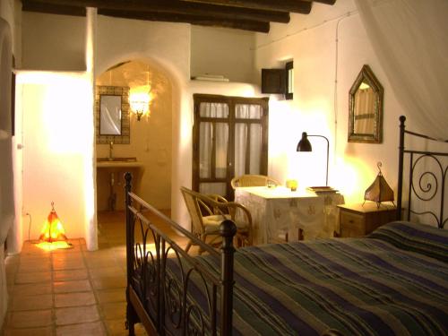 尼哈尔Hotel Rural Cortijo La Alberca的卧室配有一张床和一张桌子