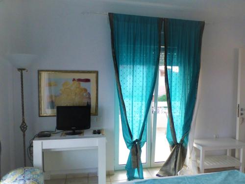 阿纳维索斯Seaview near Athens & Sounio的客房设有带蓝色窗帘的窗户。