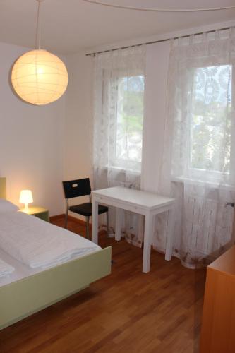 拉萨Haus Ilse & Karl Heinz的一间卧室配有一张床、一张桌子和一个窗户。