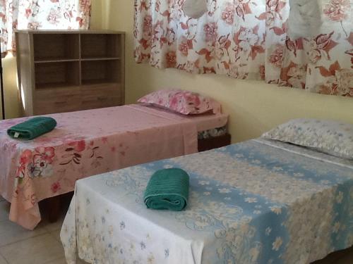 阿瓦托鲁Pension Turiroa " Chez Olga"的两张位于客房的床,配有绿毛巾