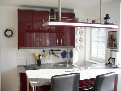 布劳恩拉格松嫩沙因公寓的厨房配有红色橱柜和白色台面