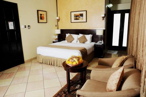 阿布扎比皇家半岛酒店的酒店客房,配有一张床和两把椅子