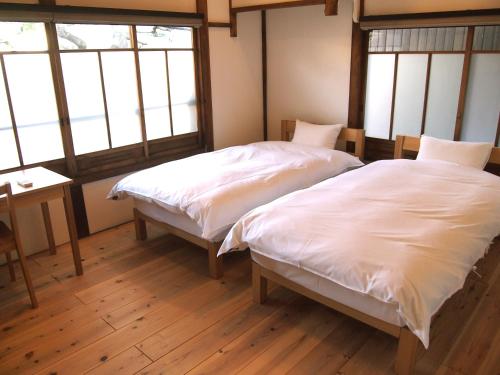 京都市松庵度假屋的带2扇窗户的客房内的2张床