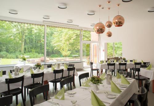 柏林克里斯托佛洛斯酒店的用餐室配有白色的桌椅和大窗户