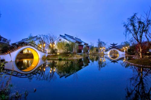 杭州杭州西溪悦榕庄的享有池塘和建筑物的景色